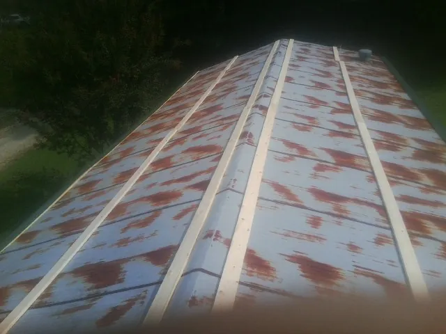 Rusted metal roof panels with new wood purlins before replacement — Storm Damage Roof Repair in Derby by Roofing Brothers