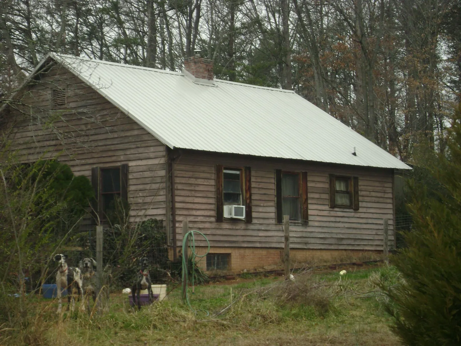 White metal roof on an old wood sided farmhouse, from a Metal Roof Installation job in Derby